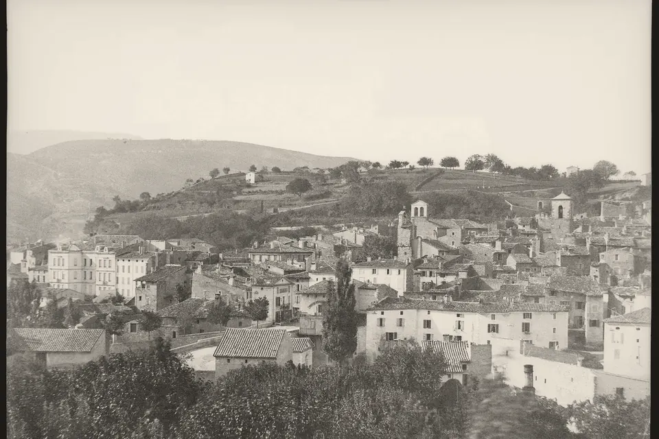 Vue ancienne de Dieulefit, maisons serrées au pied d'une colline boisée, photographie sur plaque de verre