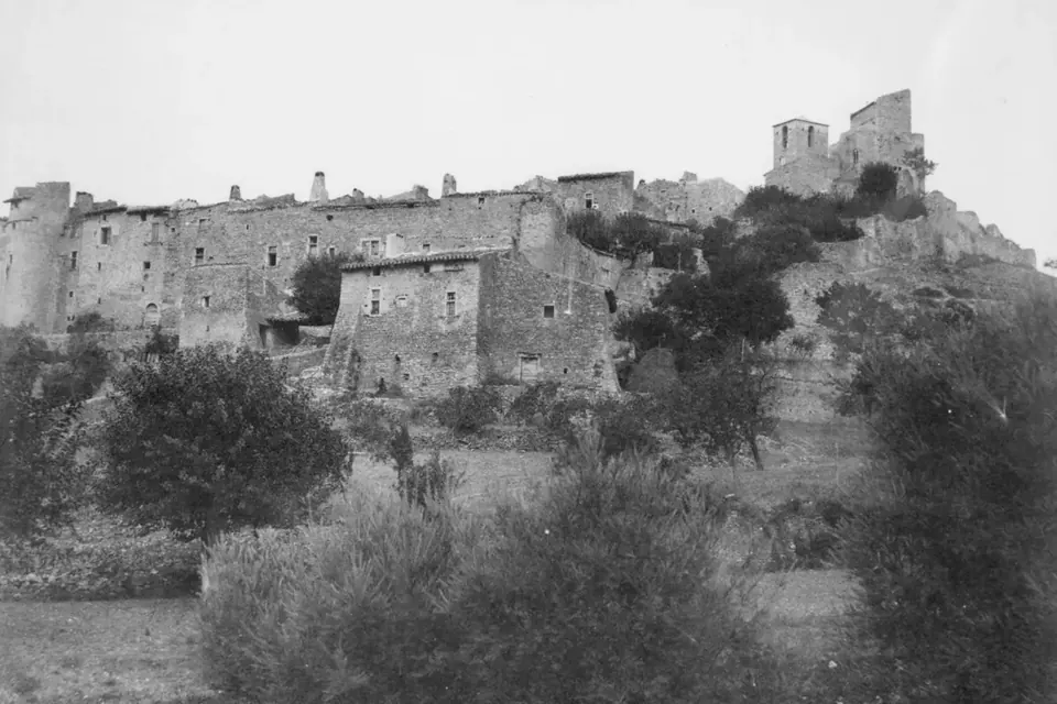 Photographie ancienne du vieux village perché du Poët-Laval, maisons de pierre et ruines dominant une colline plantée d'oliviers